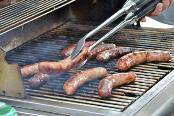 Outdoor grill cooking bratwurst